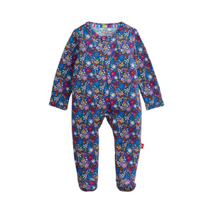 A baby footed one-piece jumpsuit with a vibrant multicolor floral pattern on a blue base, shown flat against a light off-white background.